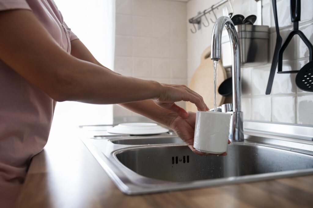 Kobieta myje swój biały kubek miekką wodą dzięki zmiękczaczowi wody