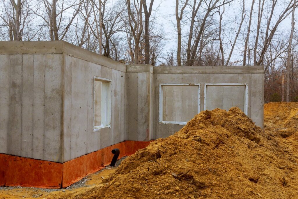 Plac budowy nowego domu z wylanym betonowym fundamentem ocieplonym styropianem
