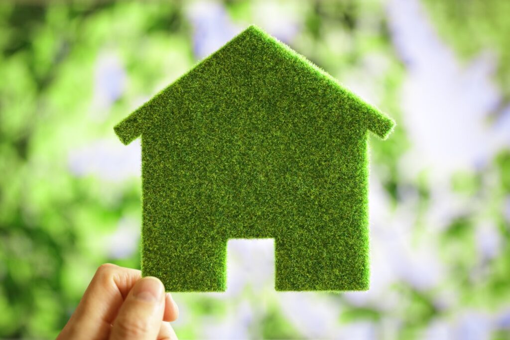 Zielony dom symbolizujący ekologię domów prefabrykowanych